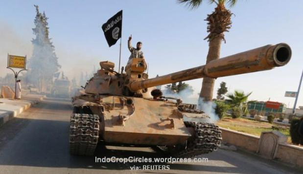 Militan ISIS di atas tank dalam parade militer di sepanjang jalan provinsi Raqqa utara, 30 Juni 2014. (REUTERS) 